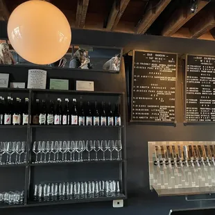 a wall of wine glasses and menus