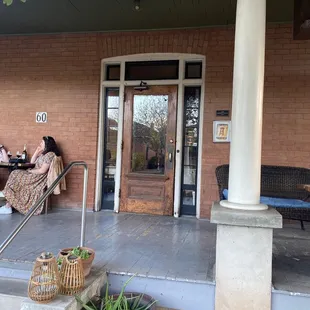 two women sitting on a porch