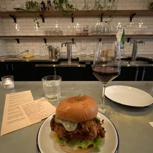 a plate with a sandwich and a glass of wine