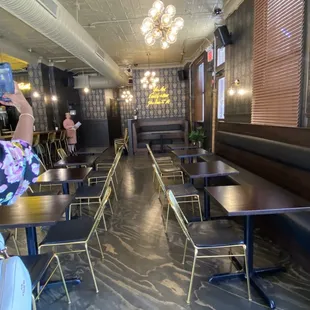 a woman taking a picture of the interior of a restaurant