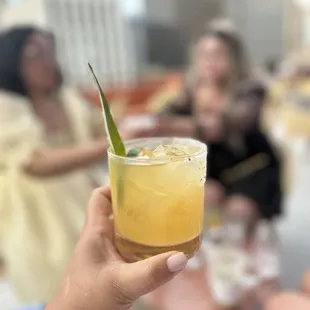 a person holding a glass of cocktail