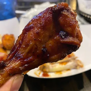 a hand holding a piece of chicken