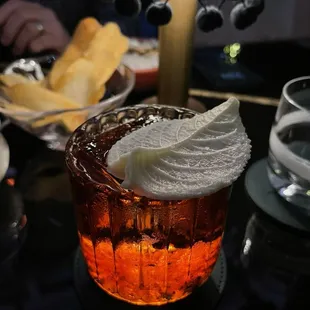 a glass of ice tea with whipped cream