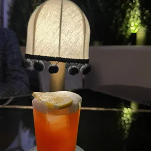 a drink in a glass with a slice of lemon