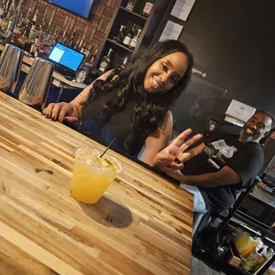 a woman sitting at a bar with a glass of orange juice