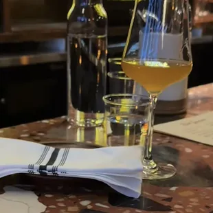 a glass of wine and a napkin on a bar