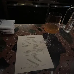 a menu and a glass of wine