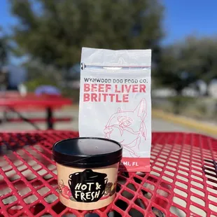 a cup of beer and a bag of beer on a table