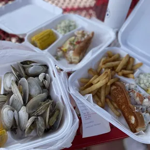 a tray of clams, fries, corn, and a hot dog