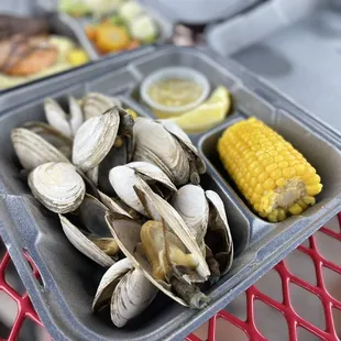 a tray of clams and corn on the cob