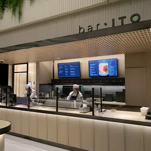 a man behind a counter in a restaurant