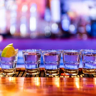 a row of shot glasses on a bar