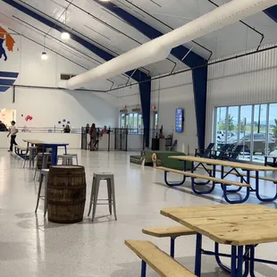 a man walking through a room with tables and benches