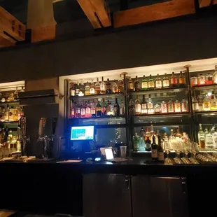 a bar with a lot of bottles on the shelves