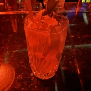 a tall glass with ice and a straw