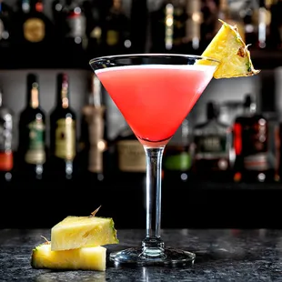a pink cocktail with pineapple garnish