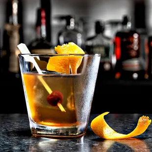 a drink with an orange garnish