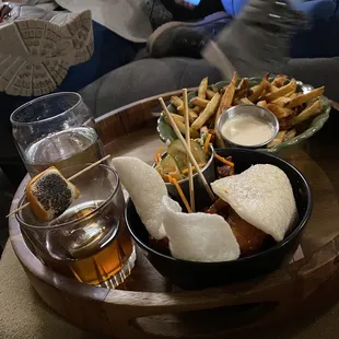 a tray of food and a glass of beer