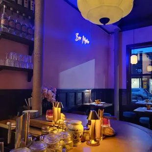 a view of a bar with a neon sign in the background