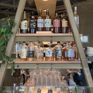 a shelf of liquor bottles and glasses