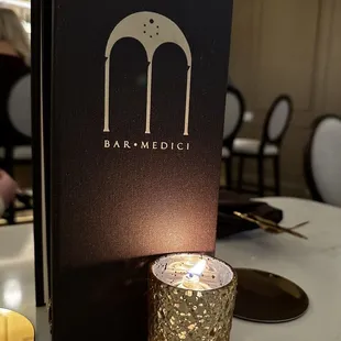 a candle and menu on a table