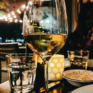 a glass of white wine on a table