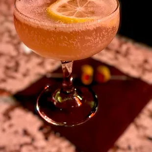 a cocktail with a slice of lemon