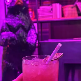 a person holding a glass of cocktail