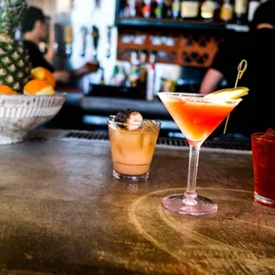 three cocktails on a bar counter