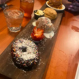 a chocolate donut with sprinkles and strawberries