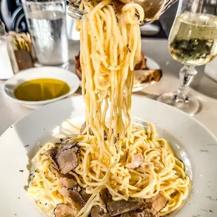 a plate of pasta being lifted by a fork