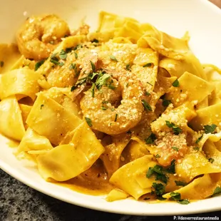 a bowl of pasta with shrimp and parmesan cheese