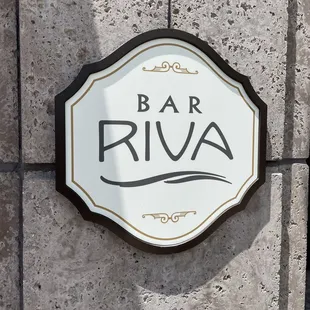 a sign on a stone wall