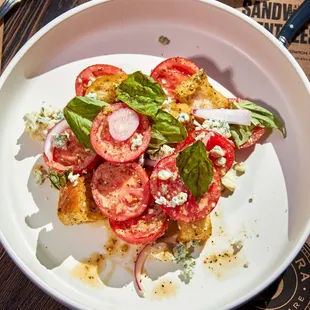 Tomato Salad - tomatoes and blue cheese tossed in herb dressing, with red onion, croutons, and basil