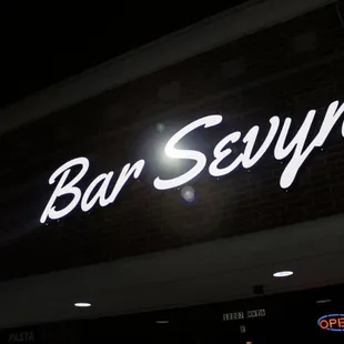 a neon sign on a brick building