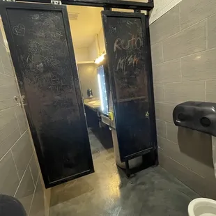 Door to the 1 stall that only half slides closed.