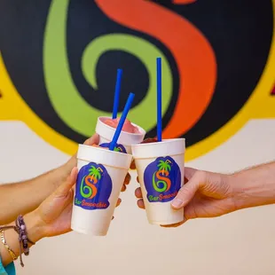 two people holding two cups of smoothie