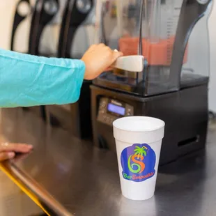 a person using a blender to make a smoothie