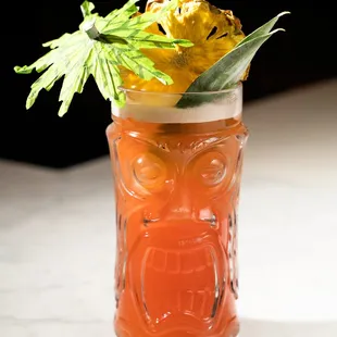 a drink in a glass with a pineapple garnish