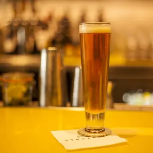 a glass of beer on a bar