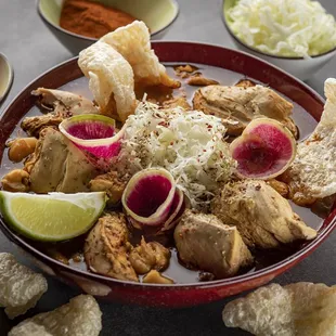 Enjoy Sopa Pozolle (Roasted Chicken Soup), with hominy, cabbage, radish, chicharron, and lime.