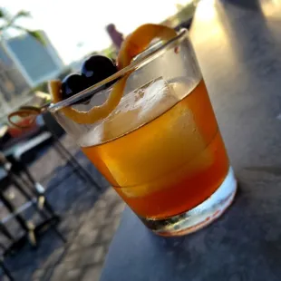 a drink with an orange garnish