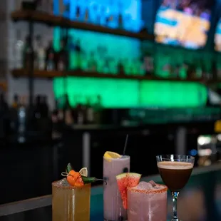 a variety of cocktails on a bar