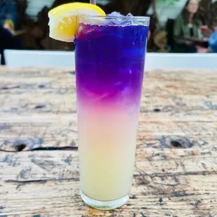 Lavender Haze - a beautiful concoction featuring house-infused butterfly pea tea gin, lemonade, soda, and lavender bitters