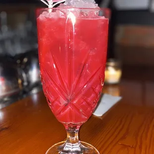 a red drink with a purple umbrella