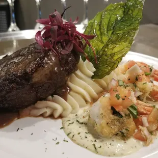 Sirloin topped with pink peppercorn au ju accompanied with parmesan encrusted prawns, tomato-basil relish, roasted garlic potato