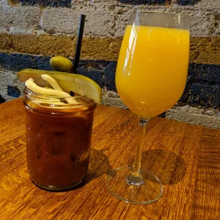 a glass of orange juice and a jar of pickles