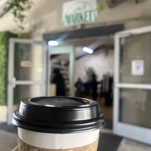a hand holding a cup of coffee