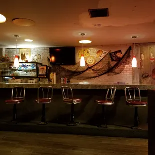 a row of bar stools in front of a bar