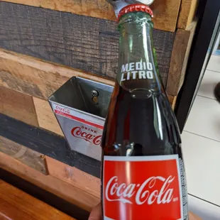 a person holding a bottle of coke